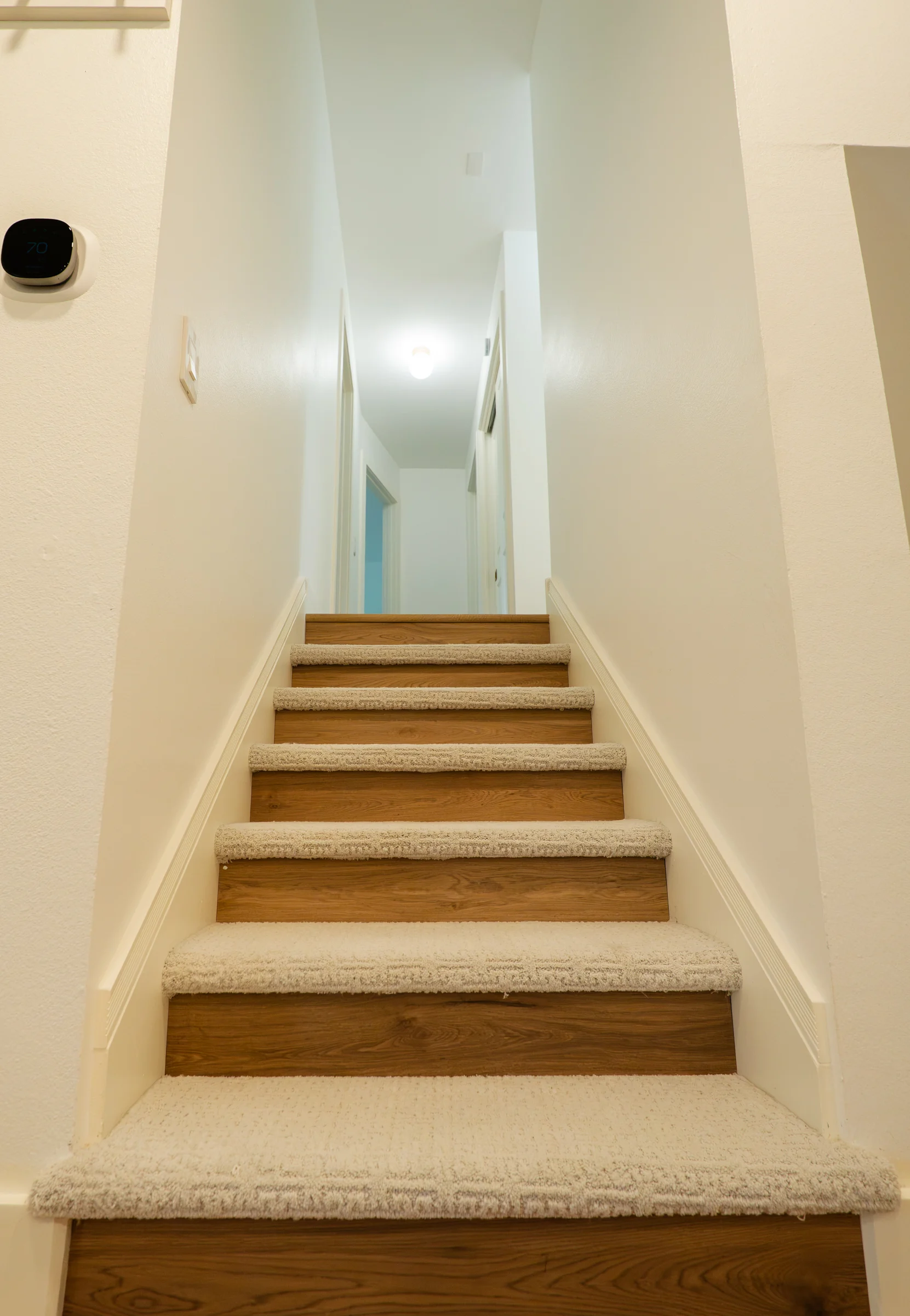 Staircase with custom wall trim, wood risers, and carpet treads, Portland OR interior millwork